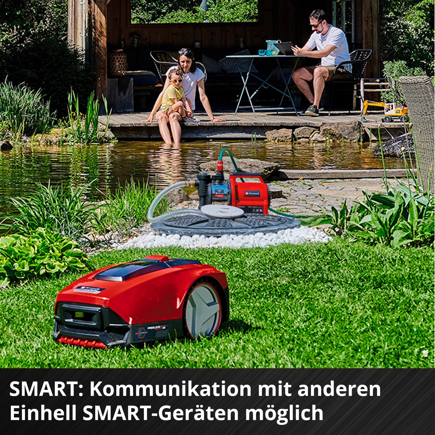 Einhell GE-AW 1144 SMART Hauswasserautomat im Garten mit Teich und Familie im Hintergrund.