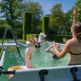 Exit Black Leather Pool mit spielenden Kindern, Poolleiter und Sandfilterpumpe im Garten.