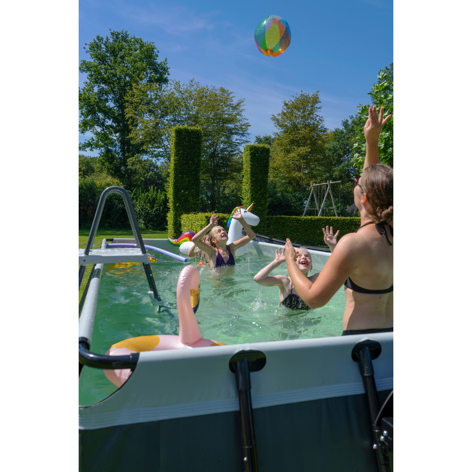 Exit Black Leather Pool mit spielenden Kindern, Poolleiter und Sandfilterpumpe im Garten.