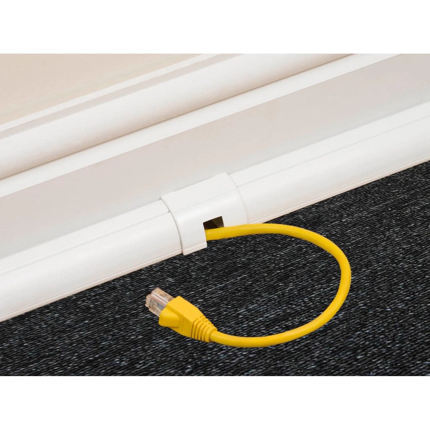 Weißer D-Line Kabelkanal (22x22mm) mit gelbem Kabel, montiert an einer Wand.