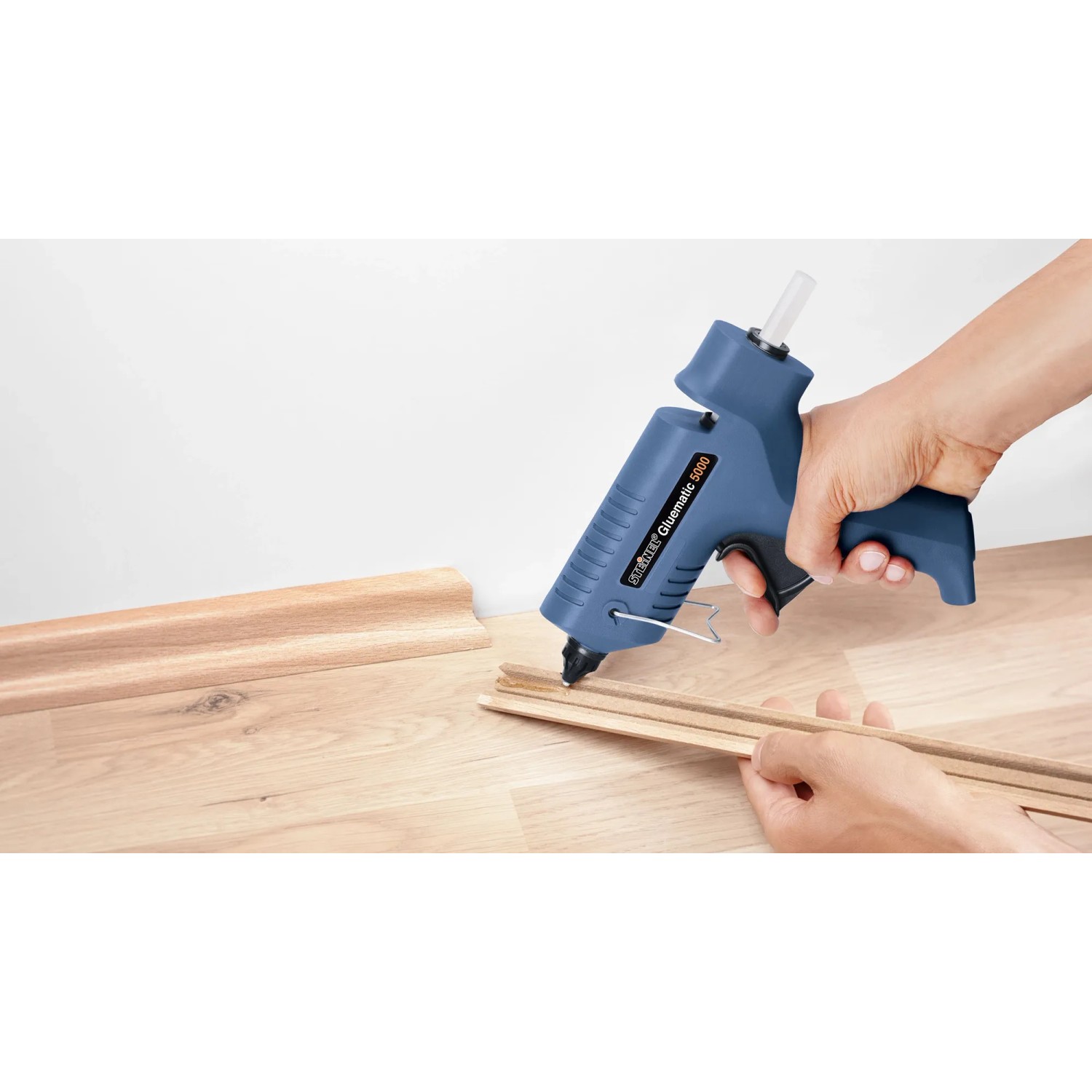 Steinel Heißklebepistole mit Klebesticks beim Verkleben von Holzleisten.