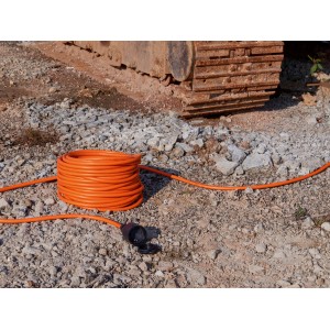 Aufgerolltes, oranges 25 m Verlängerungskabel IP44 mit Schutzkontaktstecker und -kupplung für den Außenbereich.