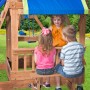 Kinder sitzen am Imbissbereich des Spielturms Northbrook aus Zedernholz mit Schaukel und Rutsche.
