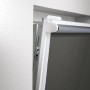 Detailaufnahme: Grau Thermo-Rollo Manresa mit Klemmträger am Fensterrahmen.