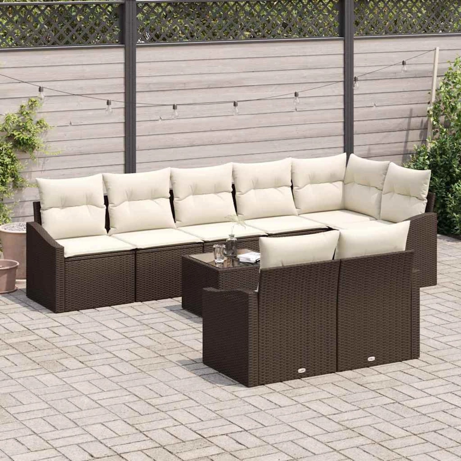 Braunes 9-teiliges Garten-Sofa-Set aus Poly Rattan mit Tisch und cremefarbenen Kissen.