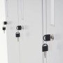 Drei helle Metall-Schließfächer mit Schlüsseln in den Drehriegelschlössern. Detail des sicheren Spind-Verschlusses für Wertfachschrank.