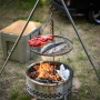 Petromax Dreibein mit Grillrost über Feuerstelle. Grillutensil für Outdoor-Küche.