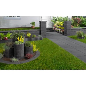 Anthrazitfarbene Gartenmauer mit Abdeckplatten und passenden Einfassungen in einem gestalteten Garten.