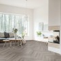 Wohnraum mit Click-Vinylboden St. Louis Oak Herringbone City im Fischgrätmuster.