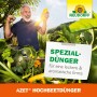 Mann freut sich über Zucchini-Ernte im Hochbeet, gedüngt mit Neudorff Azet Hochbeetdünger.