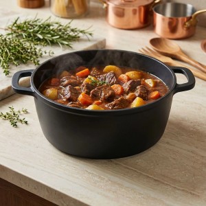 Schwarzer Relaxdays Schmortopf aus Aluminiumguss mit dampfendem Eintopf (Fleisch, Gemüse) auf Küchenzeile.