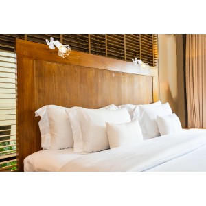 Weißer Globo Klemmstrahler Xara I mit Metallgeflecht am Holzbett montiert.