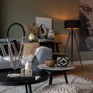 Schwarze QAZQA Stehlampe Ilse mit goldenem Schirm in Wohnzimmer-Szene.