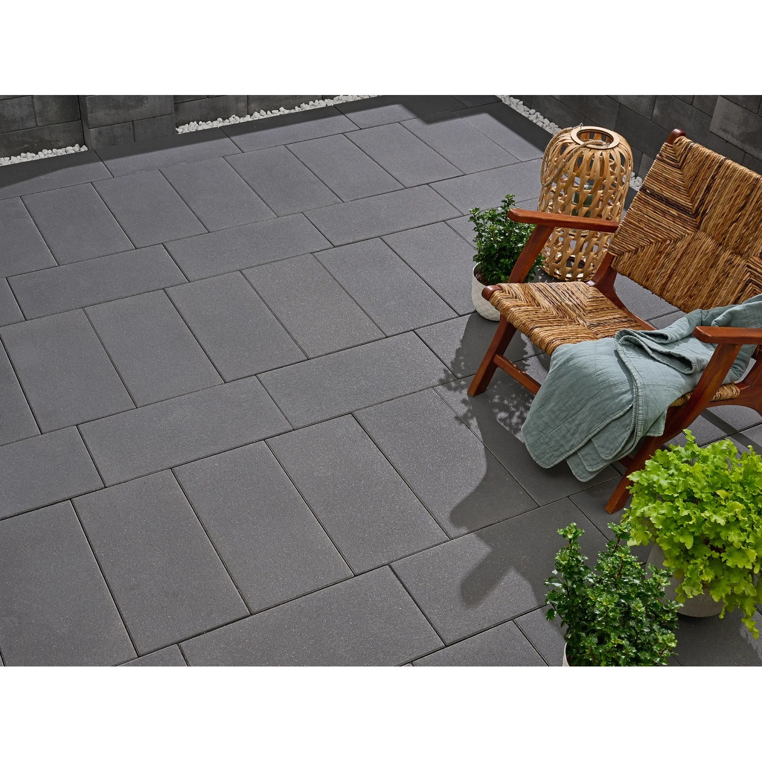 Verlegte Kann Platte Vero, 60x30 cm, Graphit, auf Terrasse mit Stuhl und Pflanzen.