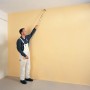 Mann streicht Wand mit Fassadenpinsel Langer Fritz 75 mm mit langem Griff.