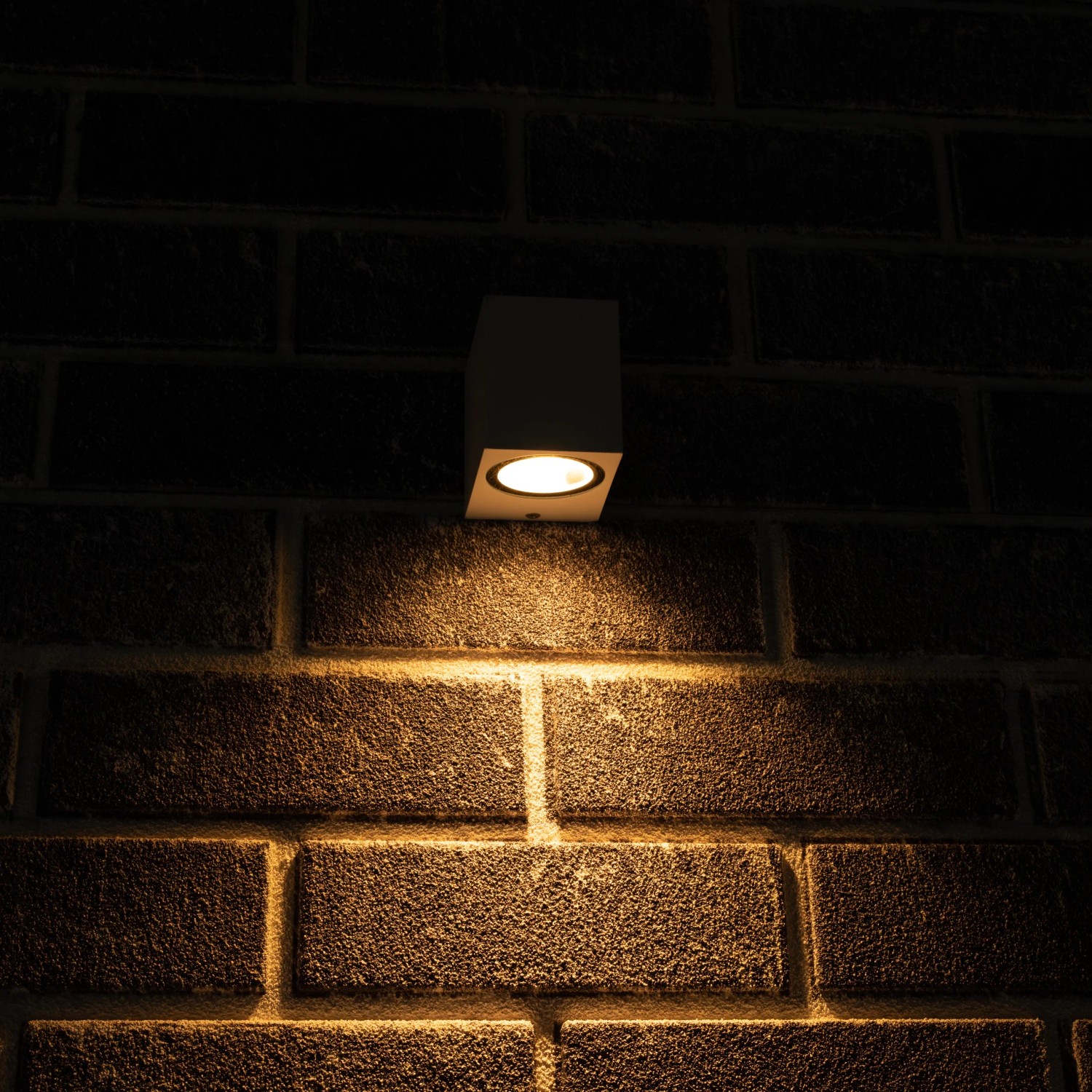 Weiße, eckige LED`s light Außenwandleuchte an einer Backsteinwand.