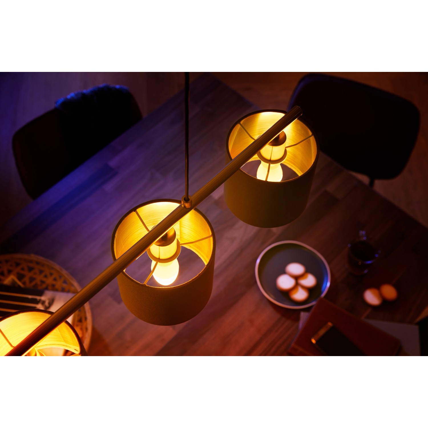 Philips Hue E14 Doppelpack: Zwei smarte Lampen mit warmweißem Licht in einer Wohnraum-Szene.