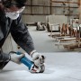 Handwerker beim Schneiden einer Platte mit dem blauen Bosch Professional Winkelschleifer GWS 750-125.
