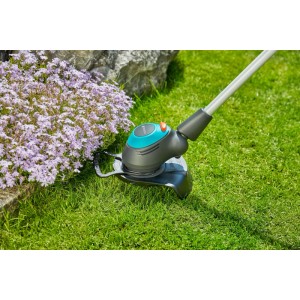 Gardena Elektro-Trimmer EasyCut 450/25 trimmt Rasen an Blumenbeet; Pflanzenschutzbügel schützt Pflanzen.