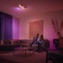 Szene mit Philips Hue Leuchte: Paar entspannt unter smartem Licht. Dimmschalter steuert die Farbtöne.
