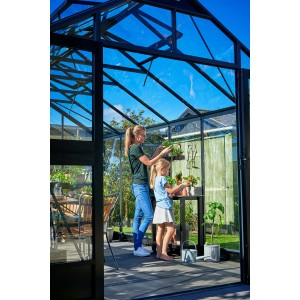 Juliana Gewächshaus Premium 13 Anthrazit mit Mutter und Tochter bei der Gartenarbeit.