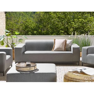 Graues Beliani Gartensofa (84x186x68) mit Kissen und Beistelltisch auf einer Terrasse.
