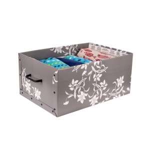 Graue Aufbewahrungsbox aus stabiler Pappe mit weißem Barock Blumenmuster, Griff. Offen, gefüllt mit Textilien. Für Ordnung.