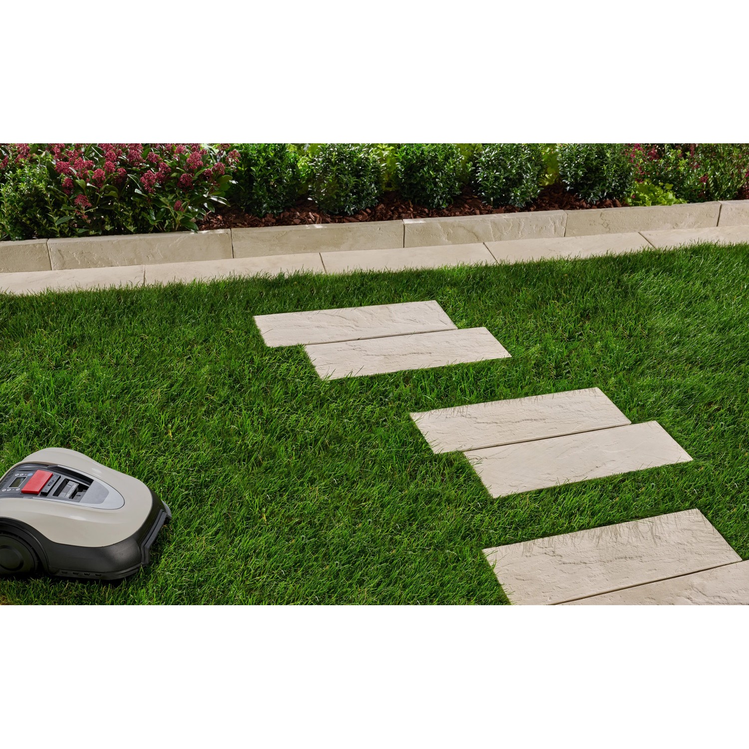 Verlegte Dielenplatten Nativa in Kalksteinoptik als Trittsteine im Garten.