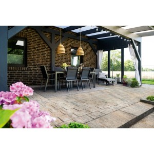 Helle Corso Mobil Terrassenplatten Muschelkalk auf einer Terrasse mit Sitzgruppe unter Pergola.