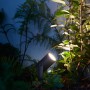 Philips Hue Lily LED-Gartenstrahler, 1-flammig, schwarz, im Gartenbeet.