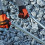 Hände mit OBI Arbeitshandschuhen (Größe 10) halten eine Schubkarre vor Steinen.