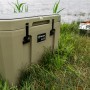Sandfarbene Petromax Kühlbox 50L im Outdoor-Einsatz. Robuste Kühlbox für Camping und Ausflüge.