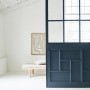 Alpina Buntlack „Himmlische Nachtmusik“: Blau lackierte Wand mit Fenster und Sitzbank im Raum.