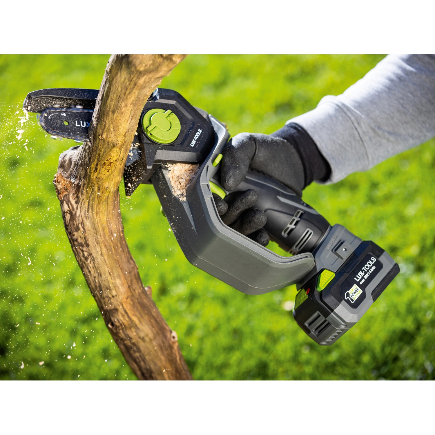 LUX-TOOLS Akku-Astsäge A-EAS-20/154 beim Sägen eines Astes. Kompakte Akku-Kettensäge für Gartenarbeiten.
