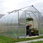 Palram Canopia Bella Gewächshaus (3.6x2.4m) in Silber mit Stegplatten. Mann gärtnert darin.