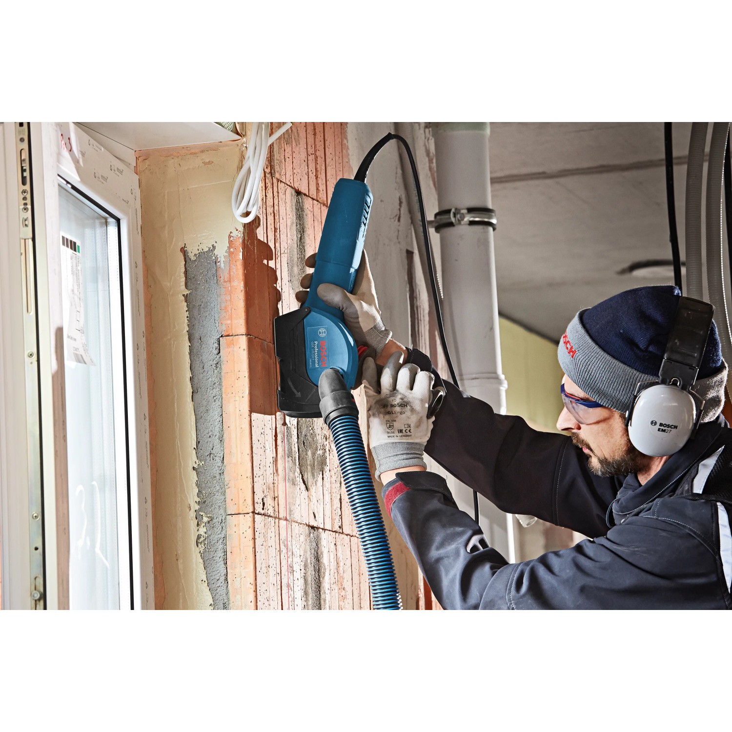 Bosch Professional GDE125EA-T Absaughaube für Winkelschleifer im Einsatz an einer Ziegelwand.