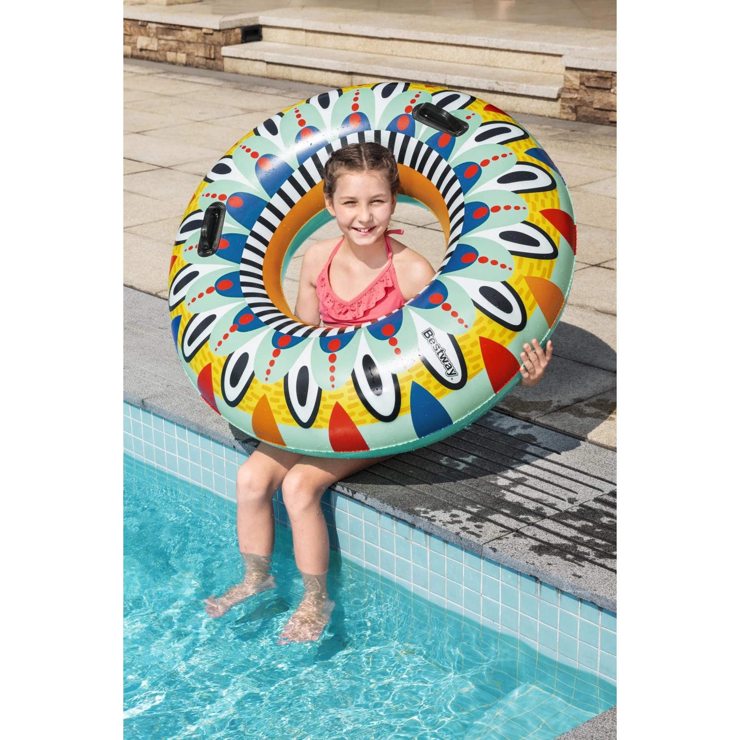 Mädchen mit bunt gemustertem Bestway Schwimmring Flirty Fiesta (Ø 94 cm) am Pool.