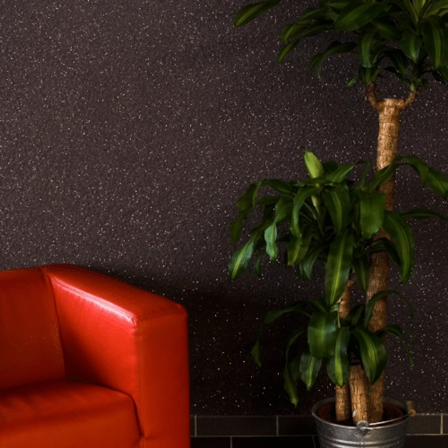 Floxxan Baumwollputz California 206 Anthrazit mit Silberglimmer, Wandgestaltung mit rotem Sofa und Pflanze.