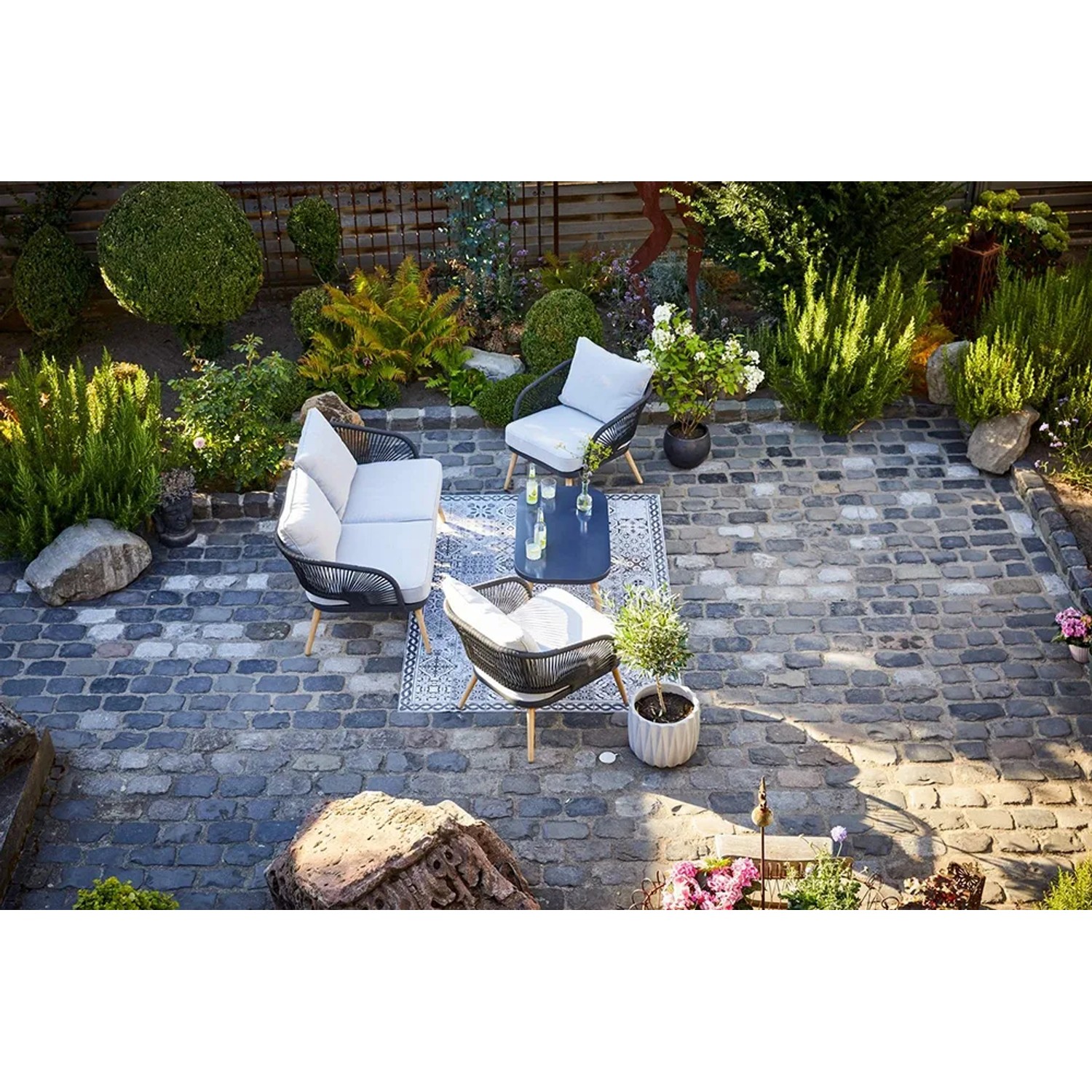 4-teiliges Lounge-Set Edna mit Seilbespannung in Anthrazit und beigen Auflagen im Garten.
