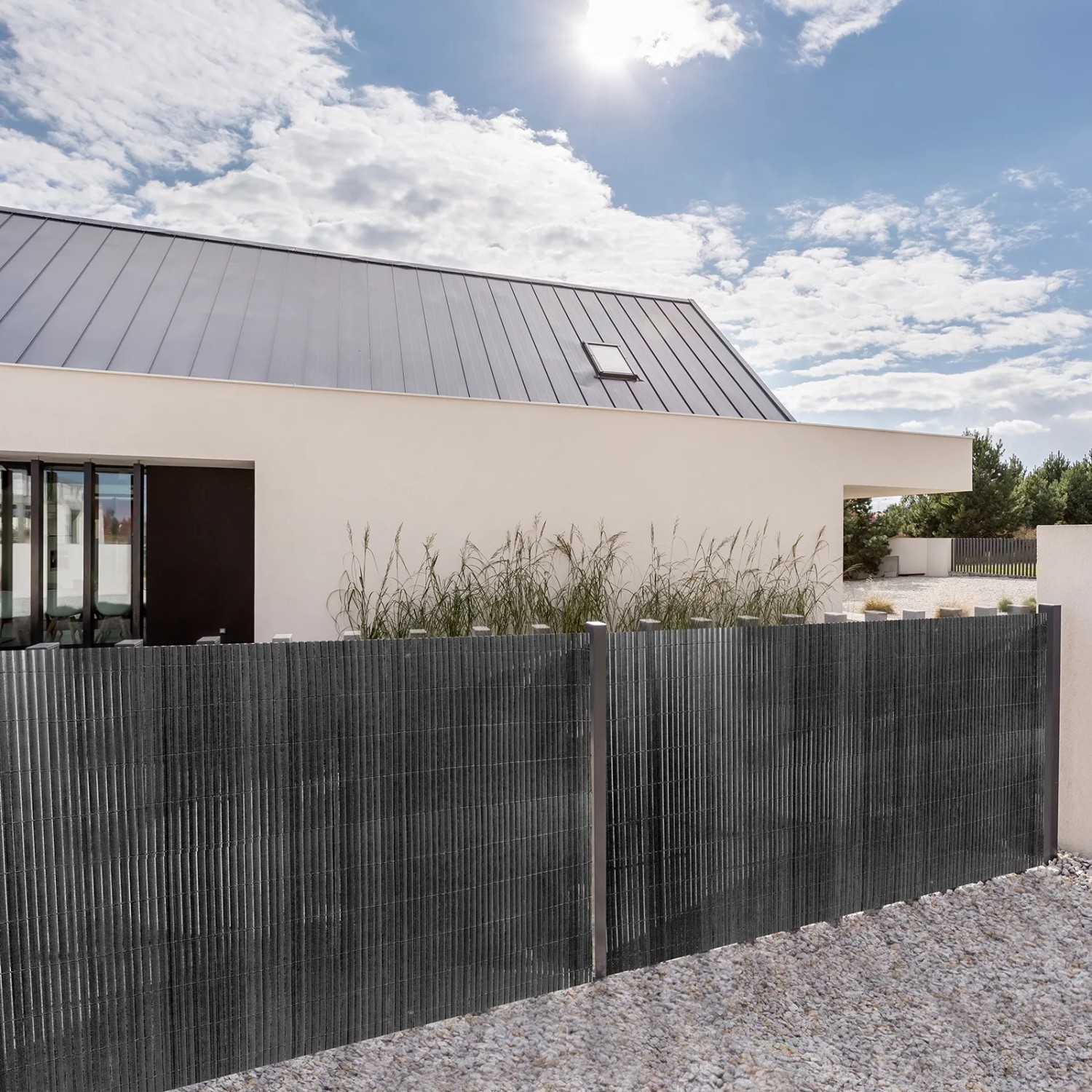 Graue PVC Sichtschutzmatte als Zaun vor modernem Haus. Wetterfest, schützt vor Blicken, Wind und Sonne.