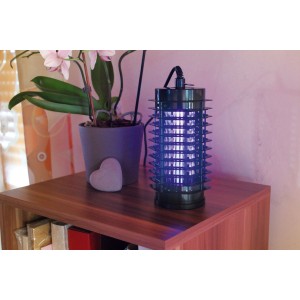 Gardigo Fluginsektenvernichter 25 m² mit UV-Licht auf einem Tisch neben einer Orchidee.