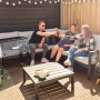 Axi Kühlwagen Retro Edelstahl 76 l mit feiernden Personen im Garten.
