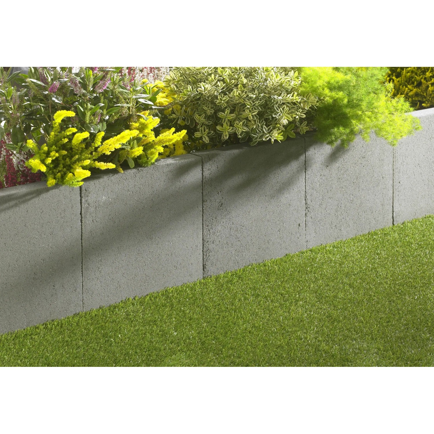 Graue EHL L-Steine (40x40x30 cm) als Beet- und Raseneinfassung im Garten.