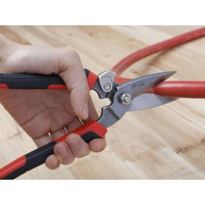 Erdi Combi-Schere D52-2 schneidet ein rotes Rohr. Zange mit rot-schwarzem Griff.