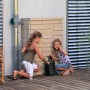 Arves Regentonne Maurano 300 l Sandstein mit spielenden Kindern im Garten.