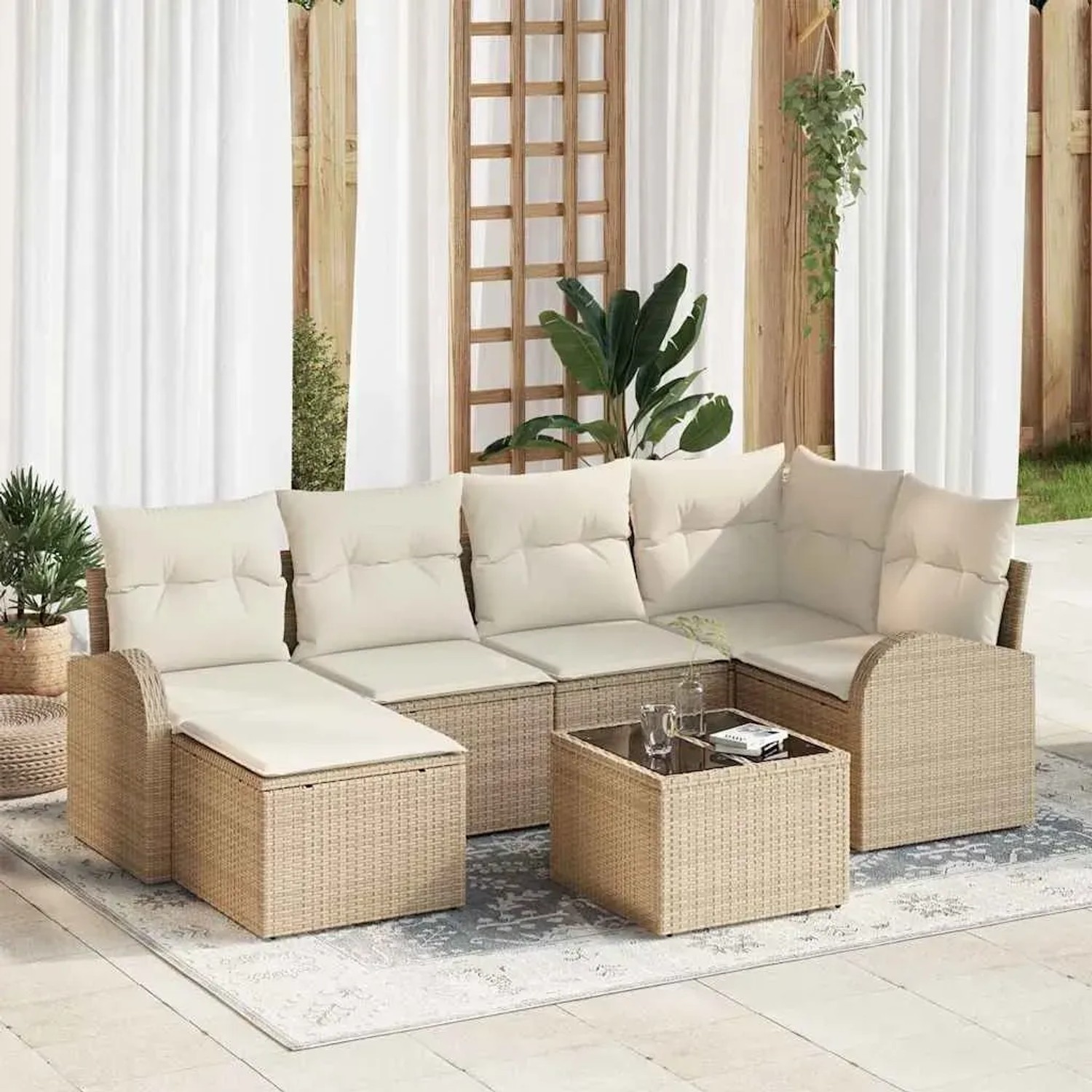 Beiges 7-teiliges Garten-Sofa-Set aus Polyrattan mit weißen Kissen und Tisch.