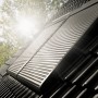 Velux Solar-Rollladen SSL CK02, dunkelgrau, auf einem Dach montiert. Hitzeschutz und Verdunkelung für Dachfenster.