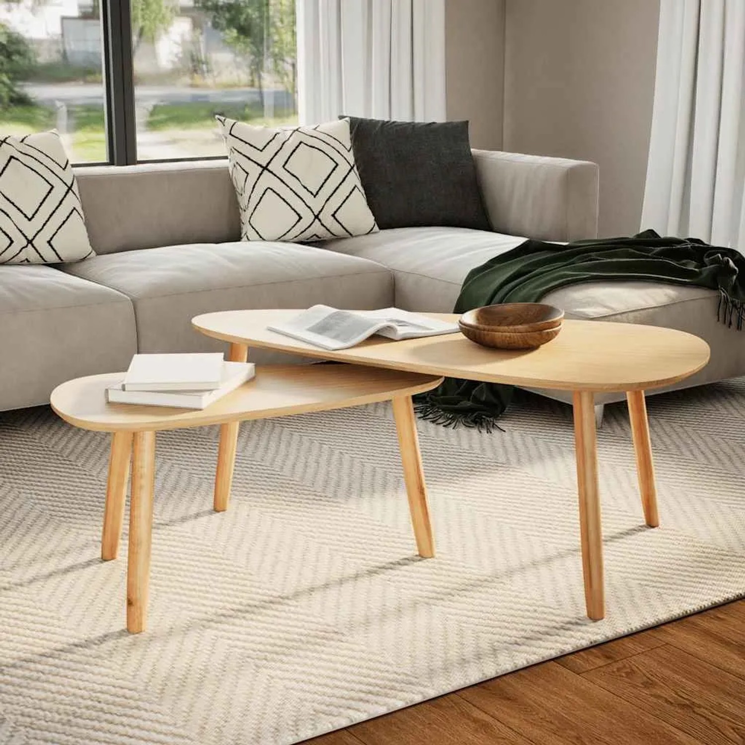Zwei ovale Couchtische aus hellem Kiefernholz mit MDF-Platten, in einem modernen Wohnzimmer auf Teppich.