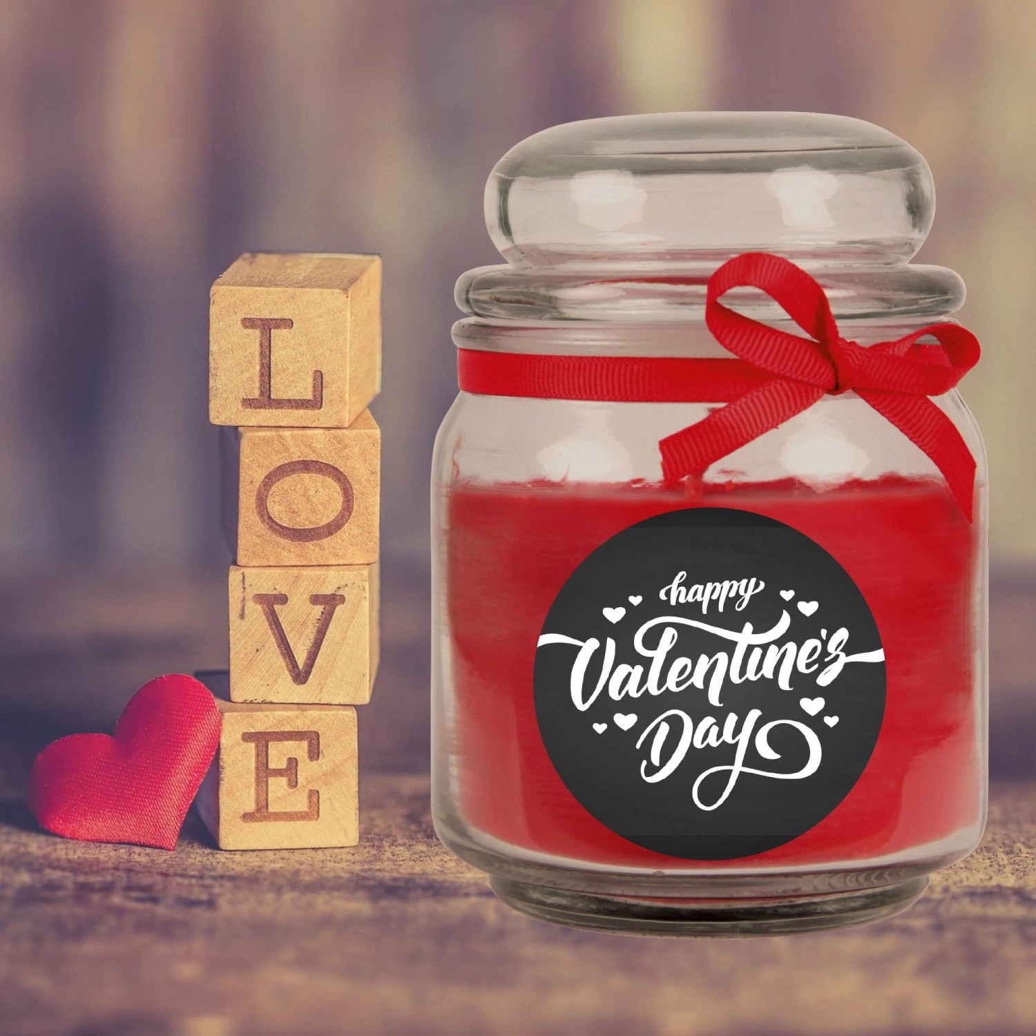 Duftkerze im Glas mit rotem Wachs, Schleife und "Happy Valentine's Day" Aufdruck. Holzbuchstaben "LOVE".