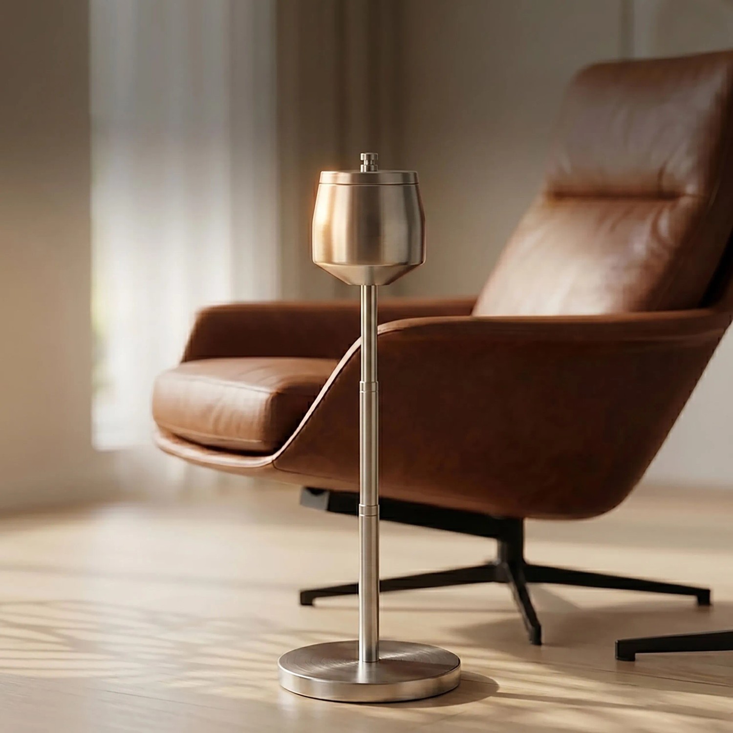Silberner Standaschenbecher aus gebürstetem Edelstahl, höhenverstellbar, neben braunem Ledersessel. Modernes Design für innen.